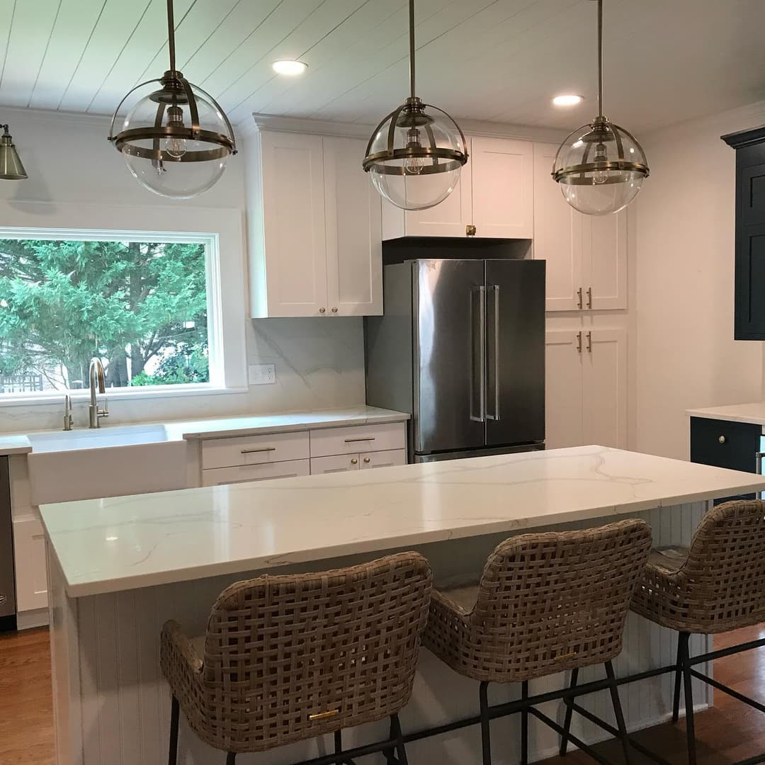 Modern kitchen featuring white cabinetry, quartz countertop, and stylish pendant lighting.