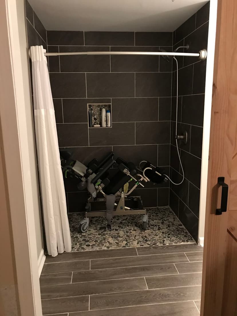 Modern bathroom with a shower and a unique weight rack on wheels for fitness equipment.