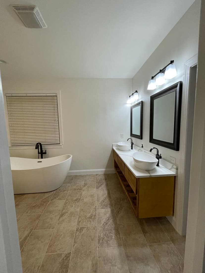 Modern bathroom design featuring a freestanding tub, double sinks, and sleek lighting.