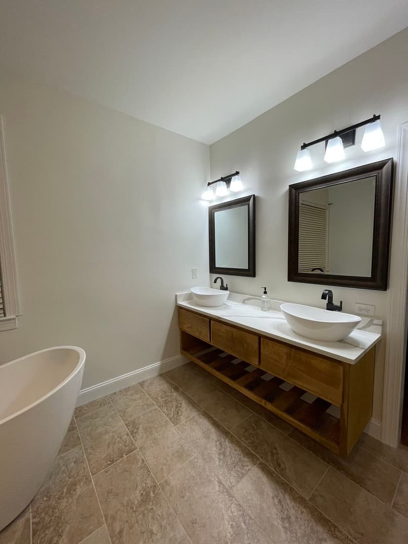 Modern bathroom design featuring double vanities, sleek mirrors, and a freestanding tub.